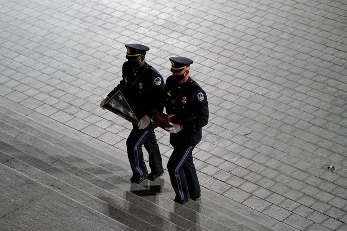 An honor guard carries an urn with the cremated remains of  Capitol Police officer Brian Sicknick and a folded American flag up the steps of the U.S. Capitol on Tuesday.