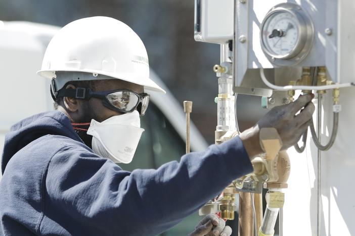 A technician adjusts the oxygen tanks for medical use at a Columbia University field hospital in April of 2020. The surging waves of cases of COVID-19 around the U.S. have led to shifting surges in demand by hospitals for extra oxygen.