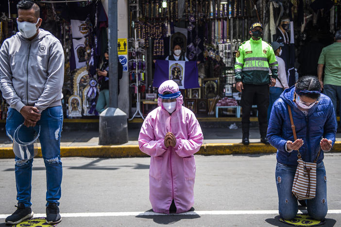 Worshippers pray in the streets of Lima. A government lockdown has shutdown churches as well as businesses to try to stop the spread of the virus.