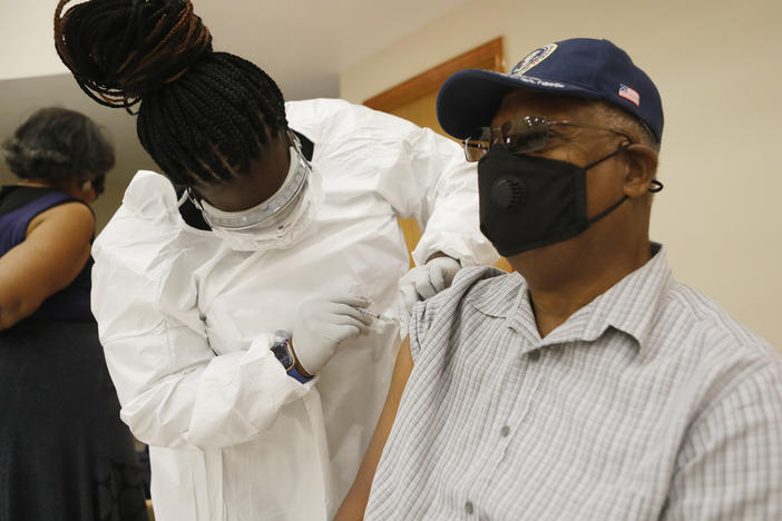 A health care worker administers the COVID-19 vaccine to a resident in Tampa, Fla., on Jan. 10. Seniors in Florida's Leon County have had trouble signing up for the vaccine and a local reporter tried to help them.