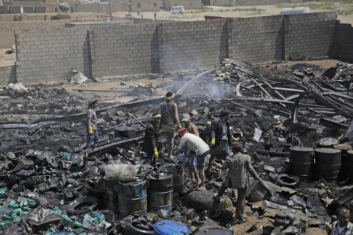 Workers salvage oil canisters from the wreckage of a vehicle oil store hit by Saudi-led airstrikes last July in Sanaa, Yemen. The U.S. said Thursday it will no longer back the Saudi-led military offensive.