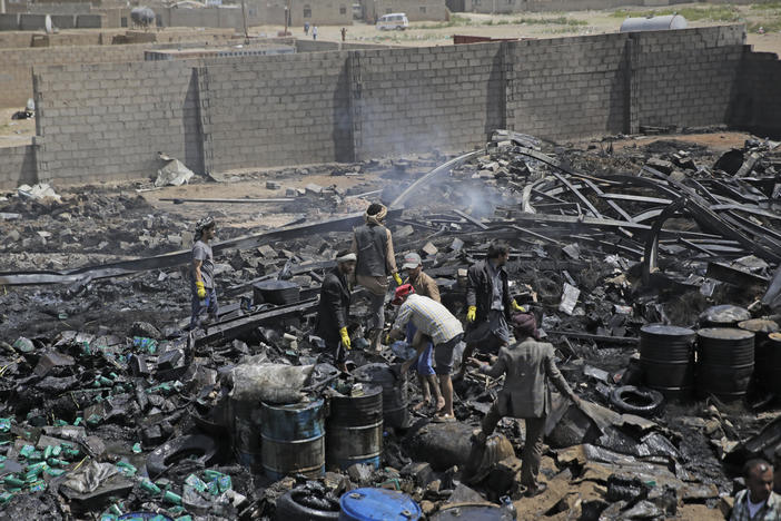 Workers salvage oil canisters from the wreckage of a vehicle oil store hit by Saudi-led airstrikes last July in Sanaa, Yemen. The U.S. said Thursday it will no longer back the Saudi-led military offensive.