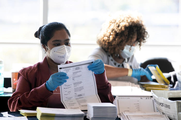 Election workers count Fulton County ballots at State Farm Arena on Nov. 4, 2020 in Atlanta. Falsehoods spread by former President Trump and his allies led to threats against election workers.