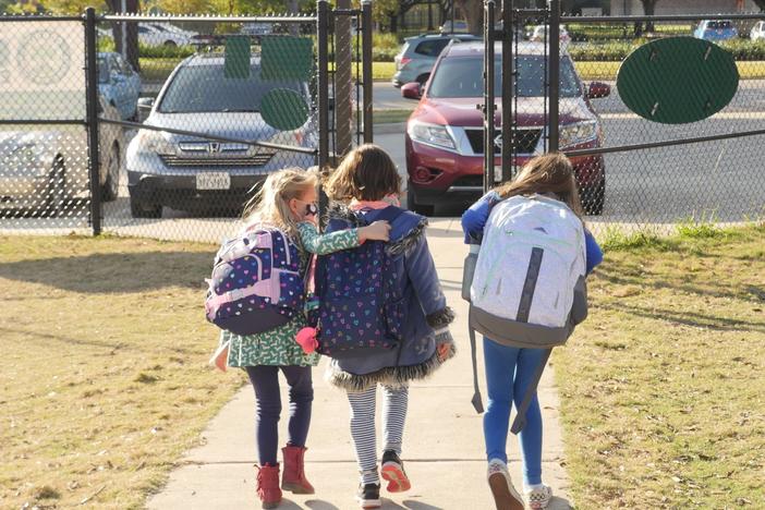 School children wearing facemasks walk outside Condit Elementary School near Houston in December. The U.S. Department of Education announced Friday that it will begin collecting data on the status of in-person learning during the pandemic.