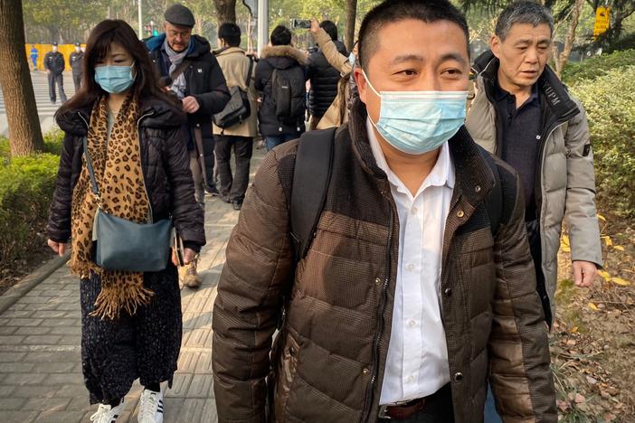 Lawyer Ren Quanniu (center), representing Chinese citizen journalist Zhang Zhan who reported on Wuhan's COVID-19 outbreak and was placed in detention since May, arrives at the Shanghai Pudong New District People's Court where Zhang is set for trial in Shanghai on Dec. 28. Ren has since been disbarred.