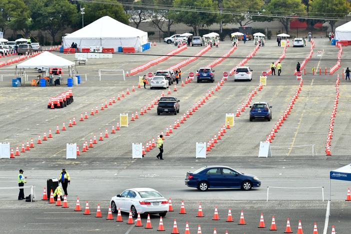 People wait for COVID-19 vaccinations in their vehicles at the Fairplex fairgrounds in Pomona, Calif., last month. The White House announced on Friday that active duty military personnel will soon be deployed to assist at vaccination sites, starting this month in California.