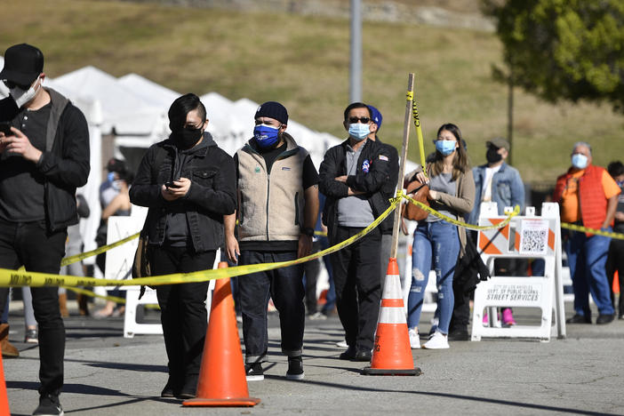 The U.S. wants at-home coronavirus testing to be widely available, to help Americans return to normal life. Here, people wait in a long line at a coronavirus testing and vaccination site at Lincoln Park in Los Angeles.