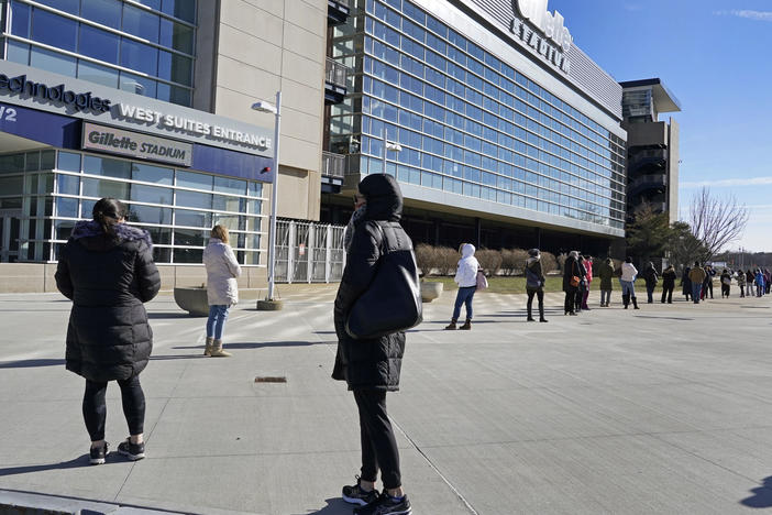 People wait in a socially distanced line to get their COVID-19 vaccinations at Gillette Stadium in Foxborough, Mass., last month. The NFL is making all 30 of its stadiums available to serve as mass vaccination sites.