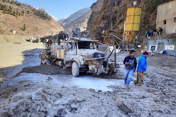 After a portion of the Nanda Devi glacier broke off in northern India on Sunday, people inspect a site near a damaged hydropower project at Reni village in Chamoli district in the country's Uttarakhand state.