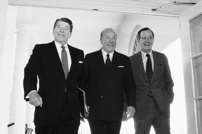 Secretary of State George Shultz, center, walks with President Reagan and Vice President George Bush on his arrival at the White House in January 1985 after two days of arms talks with the Soviet Union in Geneva. Shultz died Saturday at the age of 100.