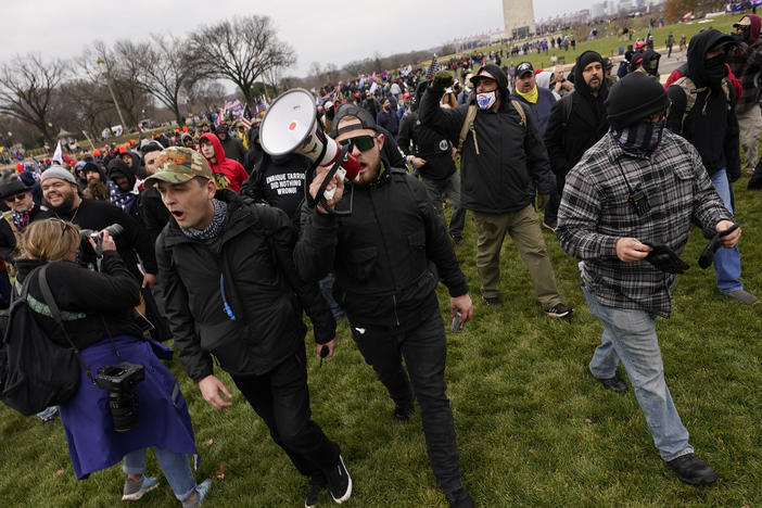 Ethan Nordean, pictured on Jan. 6 with backward baseball hat and bullhorn, leads members of the far-right group Proud Boys in marching before the riot at the U.S. Capitol. Nordean, 30, of Auburn, Washington, has described himself as the sergeant-of-arms of the Seattle chapter of the Proud Boys.