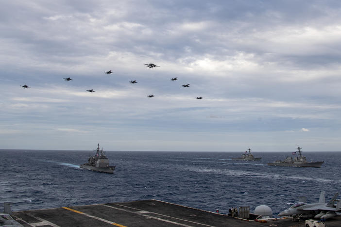 Aircraft assigned to Carrier Air Wing (CVW) 17 fly over the Theodore Roosevelt Carrier Strike Group and the Nimitz Carrier Strike Group in the South China Sea on Tuesday.