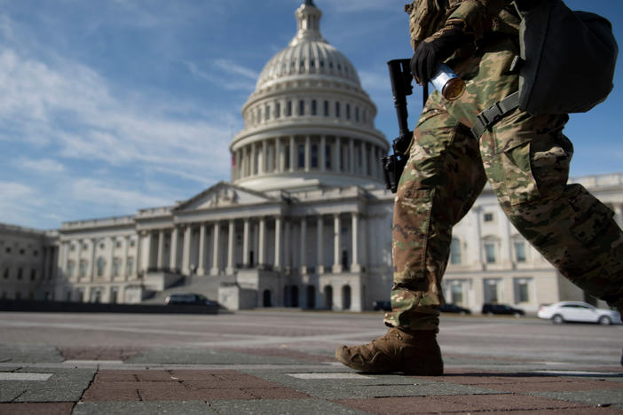 A member of the National Guard walks on Capitol Hill Tuesday, before the first day of former President Donald Trump's Senate impeachment trial.