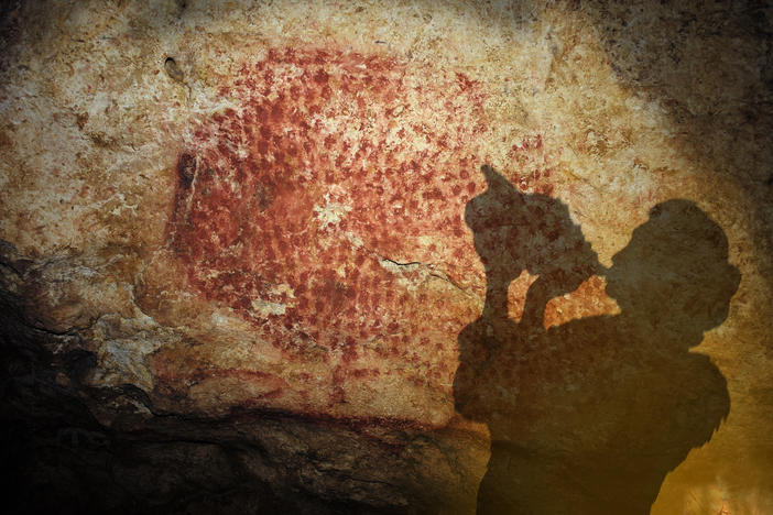 An artist's rendition of the conch of Marsoulas being played in a cave where it was found by researchers in the early 20th Century.