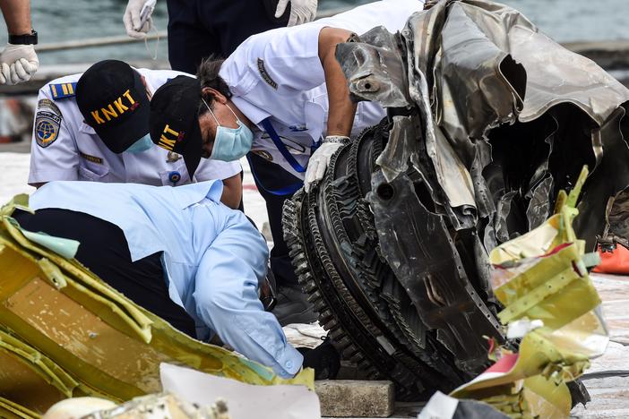 Indonesia's National Transportation Safety Committee (KNKT) officers check debris last month from the crash of a Sriwijaya Air Boeing 737-500 in  Jakarta, Indonesia.