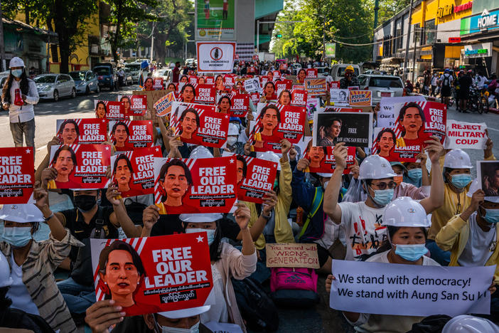 Protesters hold images of de-facto leader Aung San Suu Kyi on Wednesday in Yangon, Myanmar. As fallout from the Feb. 1 military coup continues, U.S. President Joe Biden announced plans to sanction the leaders who directed it.