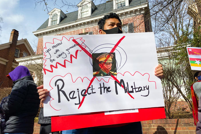A demonstrator in Washington, D.C., protesting the recent military takeover of Myanmar's government holds a sign featuring the face of the Min Aung Hlaing, the coup leader. There have been gatherings to protest the coup in front of the Myanmar military attaché's office in Northwest D.C. nearly every day since it happened on Feb. 1.