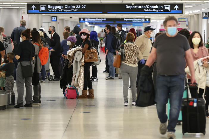 People gather their luggage after arriving at Miami International Airport on a plane from New York earlier this month in Miami, Fla.