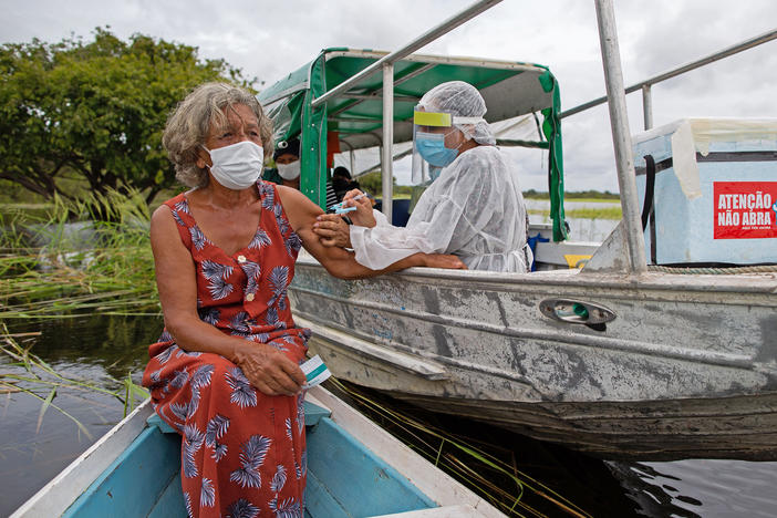 A health worker inoculates 72-year-old Olga D'arc Pimentel with a dose of Oxford-AstraZeneca's COVID-19 vaccine. She lives on the banks of the Rio Negro near Manaus, Brazil. A small study in South Africa has raised concerns about the AstraZeneca vaccine's effectiveness.