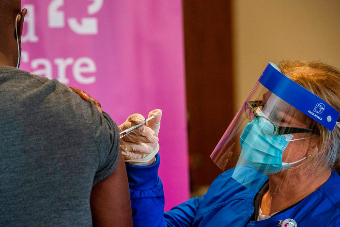 Nurse Keith Grant got his second dose of Pfizer's COVID-19 vaccine on schedule from registered nurse Valerie Massaro in January at the Hartford Convention Center — 21 days after his first immunization.