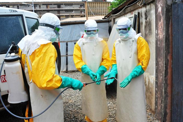 In a photo from Guinea's previous Ebola outbreak, medical staff clean their protection suits in March 2015 in Conakry, Guinea. Guinean authorities declared a new Ebola outbreak Sunday.