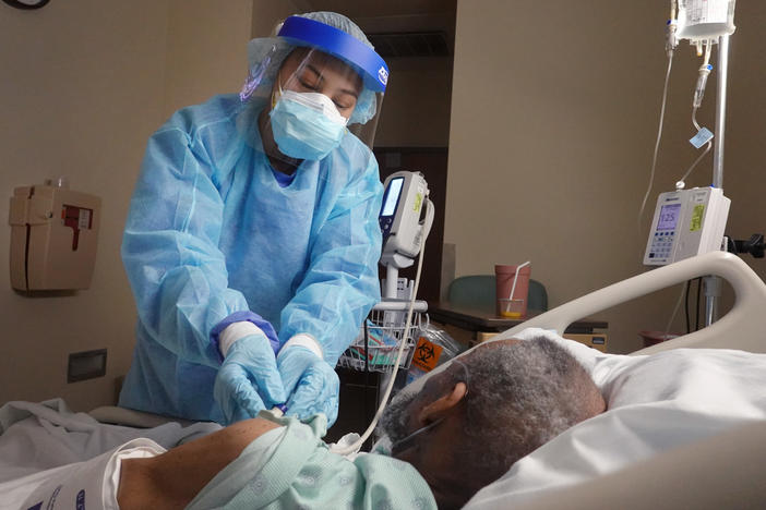 The average rate of confirmed coronavirus cases fell below 100,000 for the first time since Nov. 4, but health experts warn that highly infectious virus variants pose a serious risk to that downward trend.