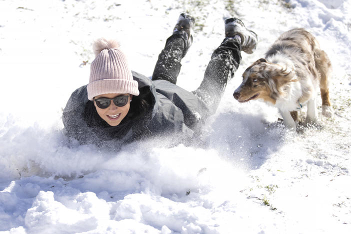 Megan Pennartz and her dog Jensen go sledding in Fort Worth, Texas, on Monday.