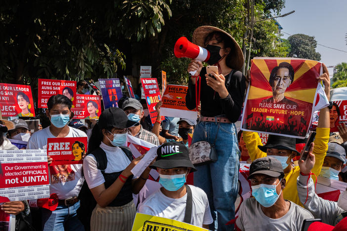 Protesters shout slogans and hold banners in front of the U.N. headquarters on Tuesday in Yangon, Myanmar, calling for the release of ousted leader Aung San Suu Kyi.