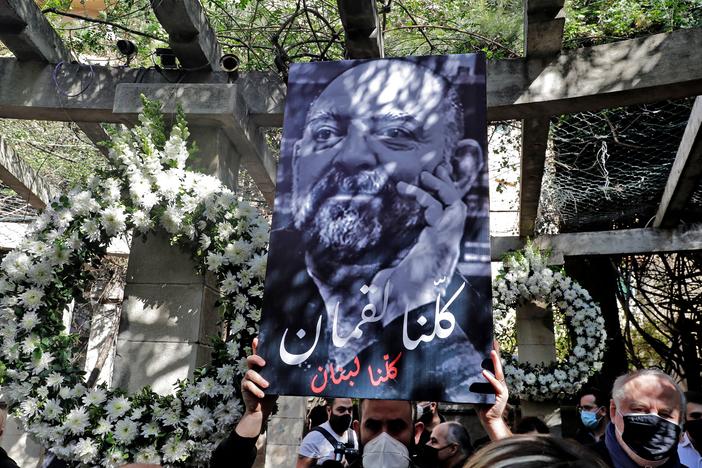 Friends and family members of slain prominent Lebanese activist and intellectual Lokman Slim (shown in the raised image), attend a memorial ceremony in the garden of the family residence in the capital Beirut's southern suburbs, a week after he was found dead in his car, on Feb. 11. Slim, 58, was an outspoken critic of Hezbollah.