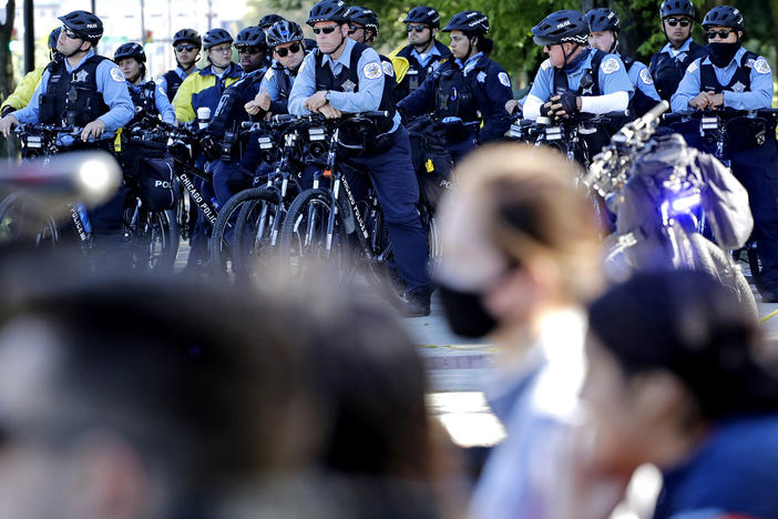 Chicago Police officers watch demonstrators on Lake Shore Drive during a protest in honor of George Floyd, in June, in  downtown Chicago. A new report says police were unprepared and ill-equipped to handle the summer's protests.