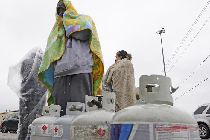 Carlos Mandez waits in line to fill his propane tanks on Wednesday in Houston. Customers had to wait over an hour in the freezing rain to fill their tanks after historic snowfall and widespread power outages in Texas.