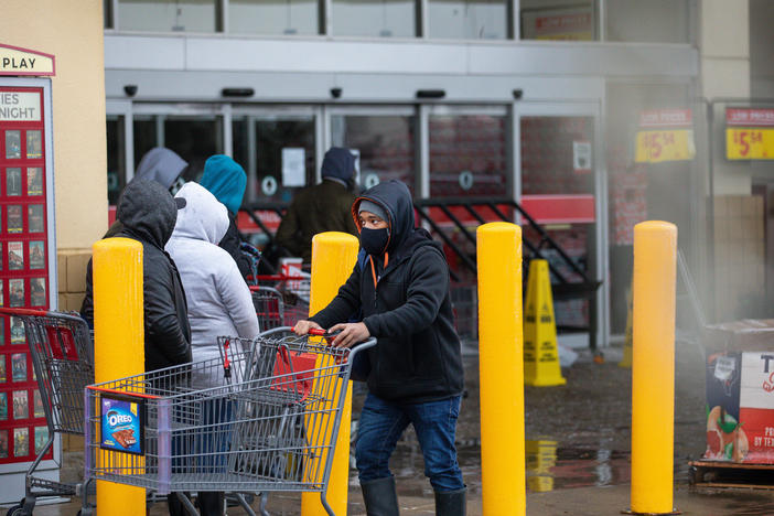 People wait in long lines at an H-E-B grocery store in Austin, Texas, on Wednesday. The large supermarket chain said the "unprecedented weather event in Texas has caused a severe disruption in the food supply chain."