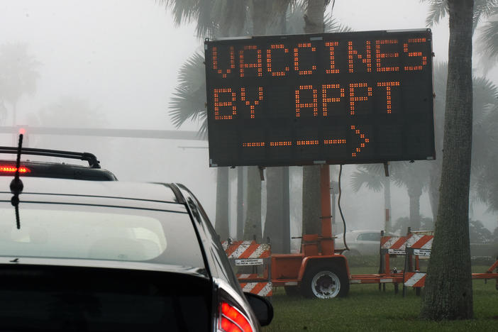 A sign directs drivers to a COVID-19 vaccination site at the Orange County Convention Center in Orlando, Fla. Health officials in Orange County said on Thursday that two women were caught dressing up as "grannies" in an effort to cut the vaccine line.
