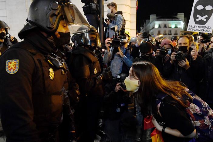 A woman talks to police during a demonstration against the imprisonment of Spanish rapper Pablo Hasél in Madrid. Clashes between police and protestors have gone on for three days and have led to dozens of arrests and injuries.