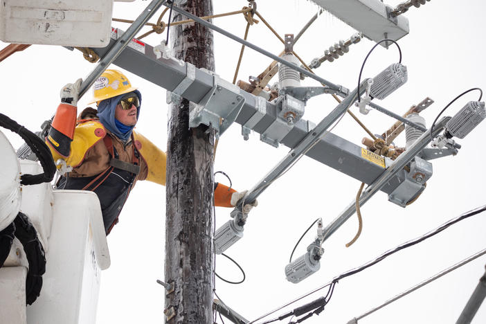 A worker repairs a power line in Austin, Texas, on Thursday. Although power was slowly being restored to much of the state, weather-related water issues persist.