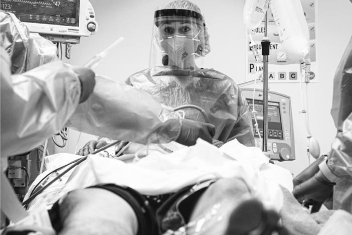 Dr. Daria Osipchuk prepares to intubate a young man in severe respiratory distress from COVID-19.