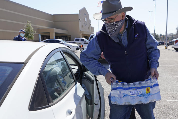 Harris County Precinct 4 Commissioner Jack Cagle hands out water at a distribution site on Friday in Houston. Millions throughout the state remain under a boil water notice as many residents lack water at home due to frozen or broken pipes.