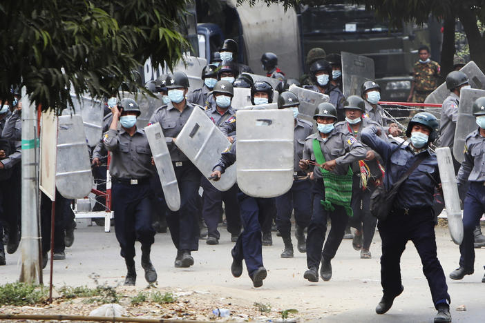 Police charge forward to disperse protesters in Mandalay, Myanmar, on Saturday. Security forces  ratcheted up their pressure against anti-coup protesters, using water cannons, tear gas, slingshots and rubber bullets.