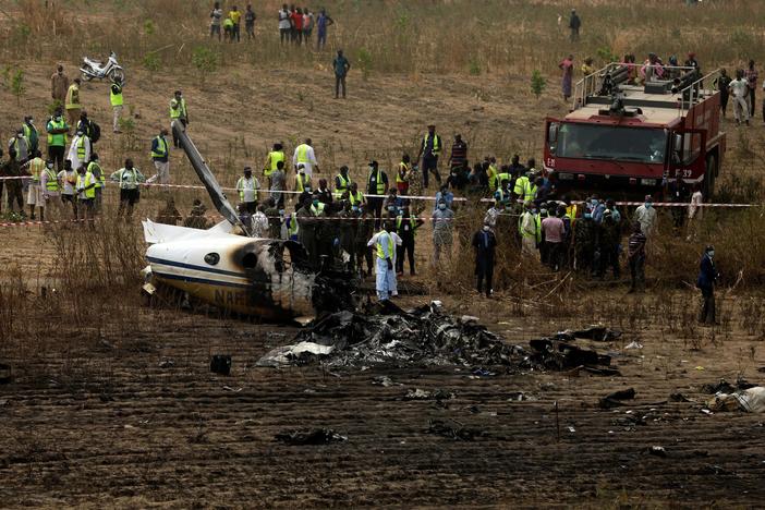 Emergency personnel work at the scene a Nigerian military aircraft crash near Abuja, Nigeria, on Sunday. All seven people on board were killed.