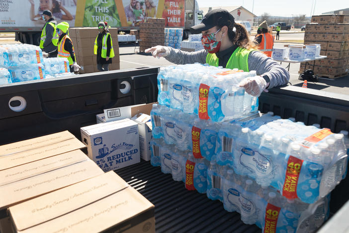 One week after winter storms triggered boil-water notices in Texas, more than 8.7 million people are still affected. Here, a volunteer loads food and bottled water at a mass distribution site in Del Valle, Texas.