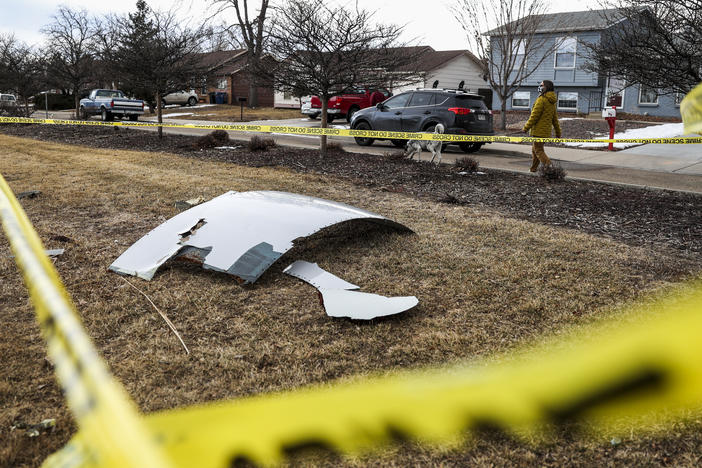 Pieces of an engine from United Airlines Flight 328 sit scattered in a neighborhood after the jet's engine failure on Saturday after takeoff from Denver.