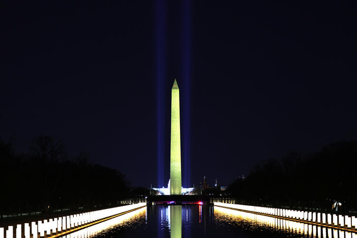 Columns along the sides of the Lincoln Memorial Reflecting Pool pay tribute to victims of COVID-19 at a Jan. 19 memorial. Just over a month later, a Monday evening ceremony will pay tribute to 500,000 Americans lives lost.