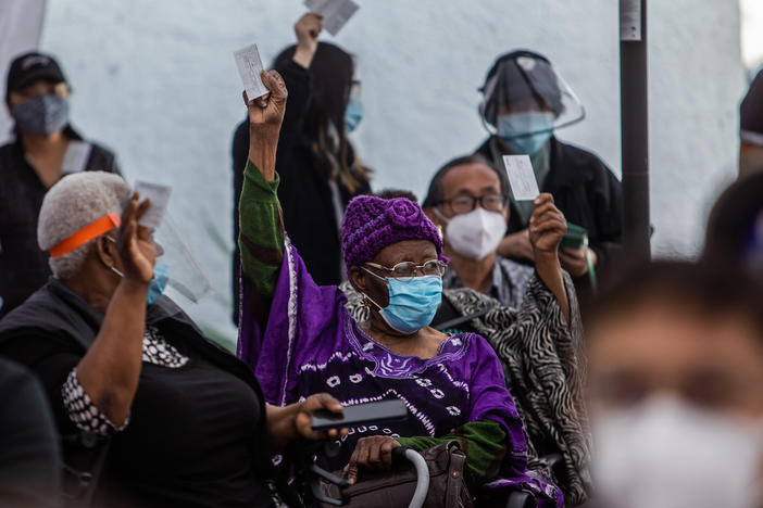 At a Kedren Community Health Center vaccine clinic in South Central Los Angeles this month, 89-year-old Cecilia Onwytalu (center) signals she's more than ready to get her immunization against COVID-19.