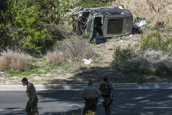 A vehicle rests on its side after a rollover accident involving golfer Tiger Woods along a road in the Rancho Palos Verdes section of Los Angeles County on Tuesday. Woods suffered leg injuries in the one-car accident and underwent surgery, authorities and his agent said.
