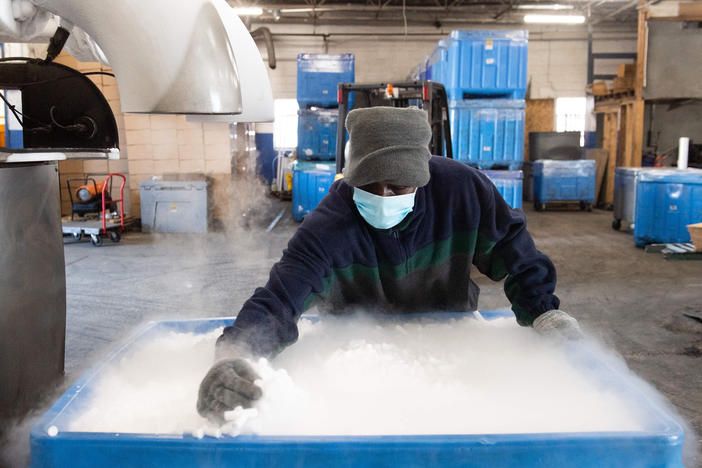 An employee makes dry ice pellets at Capitol Carbonic, a dry ice factory in Baltimore in Nov. 2020. Dry ice helps keep COVID-19 vaccines cool during transport.