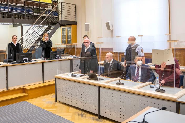 Presiding judge Anne Kerber (left) stands before handing the verdict to Syrian defendant Eyad al-Gharib (right, face hidden under a folder) Wednesday in Koblenz. Gharib, 44, a former Syrian intelligence service agent, was sentenced to 4 1/2 years in jail for complicity in crimes against humanity in the first court case over state-sponsored torture by the Syrian government.