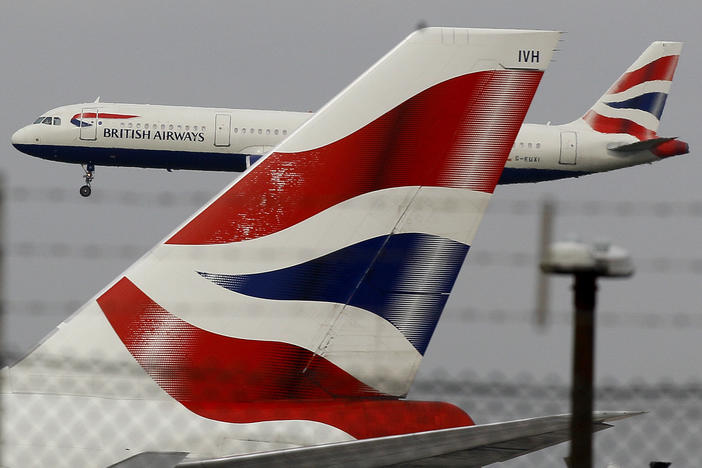 A British Airways plane comes in to land behind a tail fin at Heathrow Airport in London. On Friday, the head of the group that owns BA called for instituting an electronic health pass for passengers as the company announced steep losses due to COVID-19.