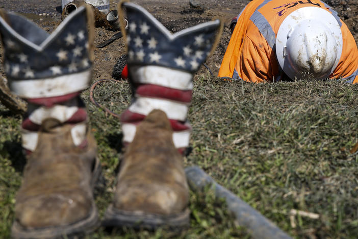 A worker fixes a water pipe in Galveston, Texas, on Feb. 19. The power is back on in much of the state, but the Lone Star State now faces the hefty cost of emerging from its devastating storms.