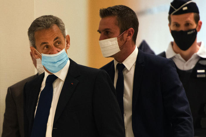French former President Nicolas Sarkozy (left) arrives to hear the verdict in a corruption trial at Porte de Clichy court house in Paris on Monday.