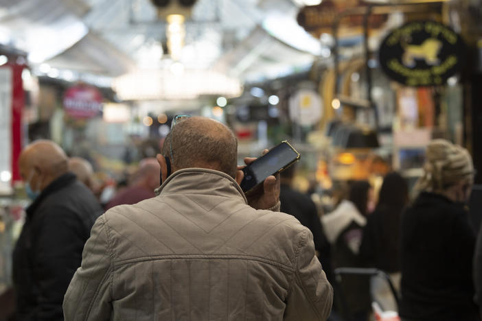 A man speaks on his mobile phone in the Mahane Yehuda market in Jerusalem in December. In the early days of the pandemic, Israel began using a mass surveillance tool on its own people, tracking civilians' mobile phones to halt the spread of the coronavirus.